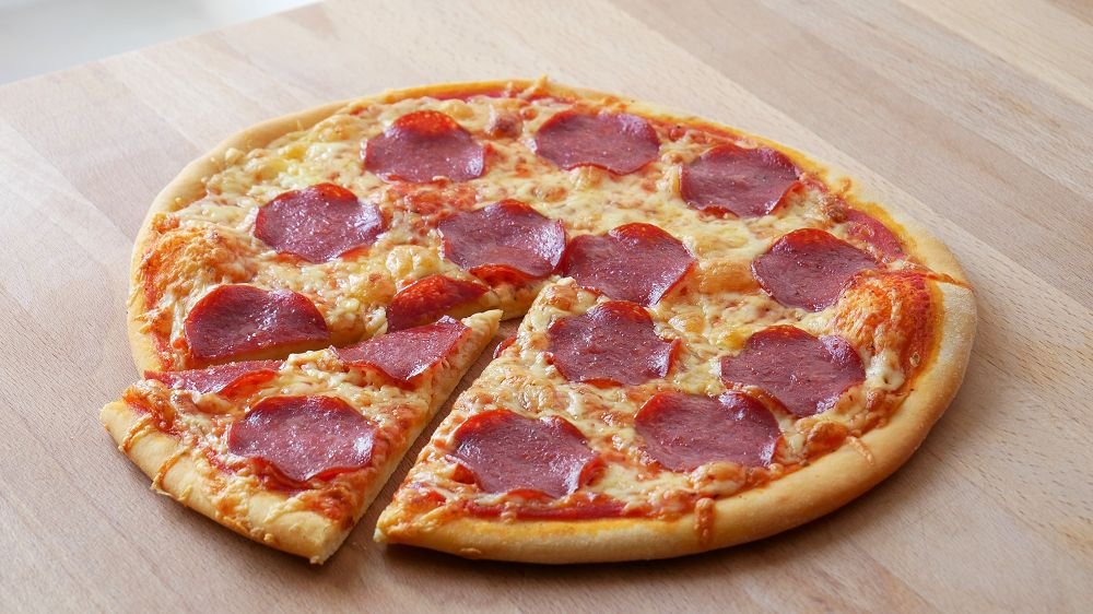 Image of a pizza on a table, sliced
