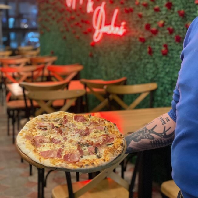 A man holding pizza at 3 Fiori Fast Food Vlore