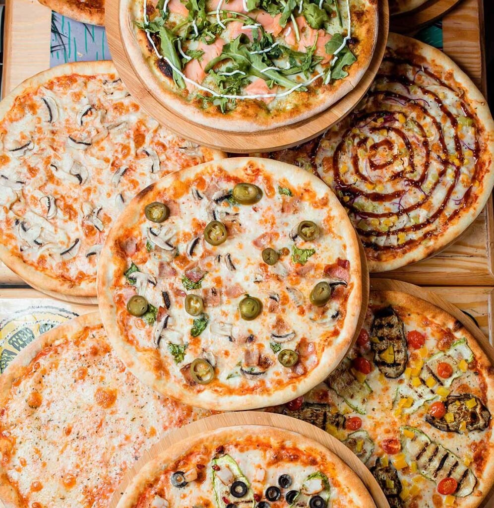 Photo of many pizzas on a table